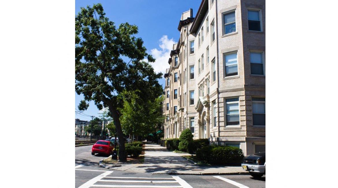 Four stroy apartment buildings on tree-lined street
